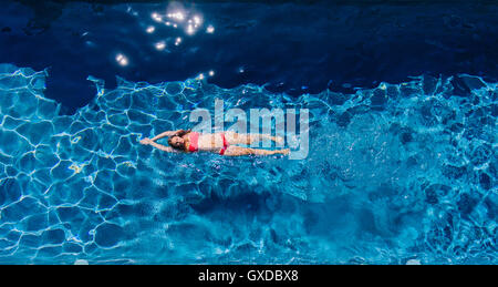 Vista aerea della donna nuoto sul retro in piscina Foto Stock