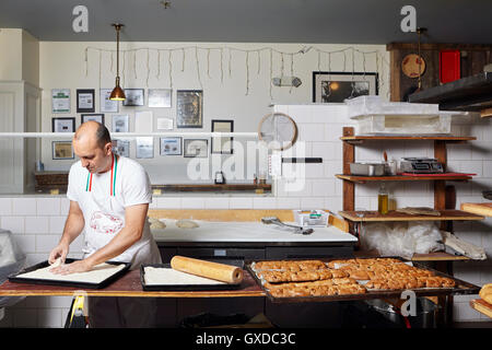 Baker lavora nel panificio Foto Stock