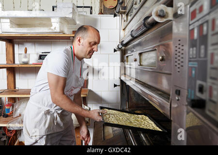 Baker lavora nel panificio Foto Stock