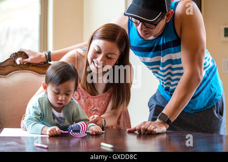 I genitori e il bambino con la bandiera americana, il pastello disegno in sala da pranzo Foto Stock