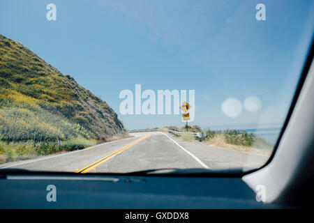 Parabrezza auto vista della costa di avvolgimento road, Big Sur, CALIFORNIA, STATI UNITI D'AMERICA Foto Stock