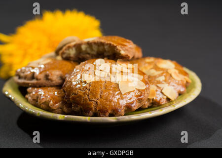 Tipico olandese piccante riempito i biscotti con mandorle in autunno colorato e lo sfondo scuro Foto Stock