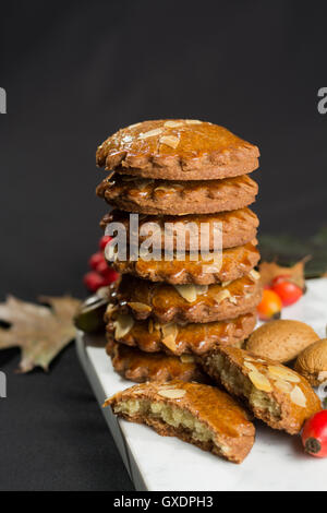 Tipico olandese piccante riempito i biscotti con mandorle in autunno colorato e lo sfondo scuro Foto Stock