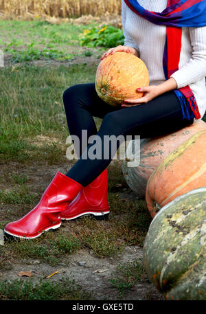 In autunno la zucca pioggia rossa e scarpe di legno con sfondo leavs. Foto Stock