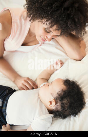 Guardare la madre figlio bambino che dorme sul letto Foto Stock