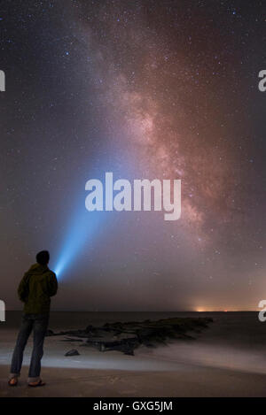 Uomo asiatico shining torcia elettrica sul cielo stellato Foto Stock