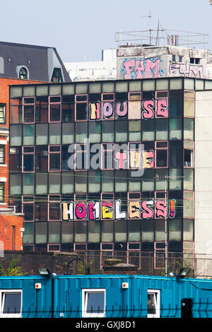 Casa i senzatetto  scritte poste in windows non occupato di beni abbandonati in Manchester, Regno Unito Foto Stock