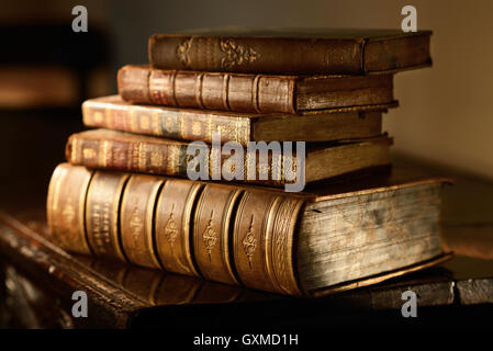 Libri Vintage stack su legno di antiquariato in superficie calda luce direzionale. Grunge e messa a fuoco selettiva. Foto Stock