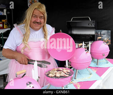 Bremen, Germania. Xvii Sep, 2016. Carsten Kuehl dal team tedesco 'Barbie-Q' indossando un rosa baby doll costume cuochi ali di pollo in rosa griglie compatta durante la European Championship BBQ a Bremen, Germania, 17 settembre 2016. 36 squadre provenienti da 15 paesi stanno prendendo parte al campionato. Foto: INGO WAGNER/dpa/Alamy Live News Foto Stock