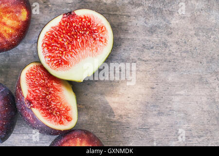 Fresche e mature fichi nero su grigio rustico sfondo di legno. Vista da sopra con lo spazio di copia Foto Stock