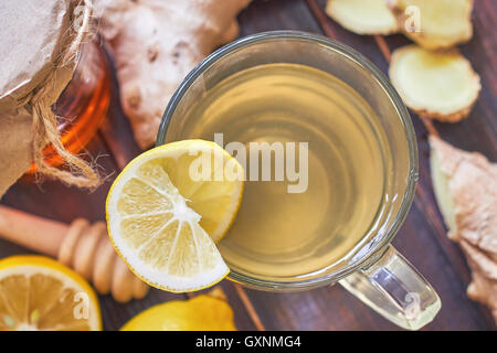 Il tè allo zenzero servito con miele e limone su un tavolo di legno. Vista superiore Foto Stock