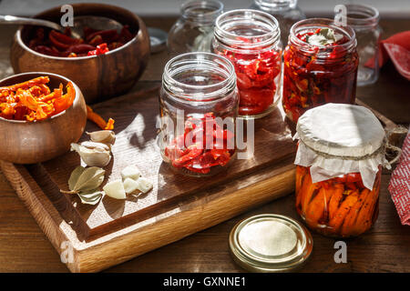 Pomodori secchi con erbe aromatiche e sale marino in olio di oliva in un vasetto di vetro Foto Stock