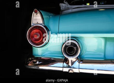 Chrome rear tail lights, bumper and exhaust of convertable turquoise vintage car. Foto Stock