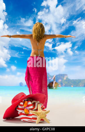 Vista di un womanstanding sulla spiaggia con cappello di paglia e borsa da spiaggia - incentrata sul sacchetto Foto Stock