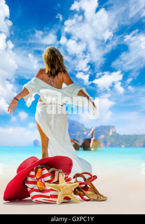 Vista di un womanstanding sulla spiaggia con cappello di paglia e borsa da spiaggia - incentrata sul sacchetto Foto Stock