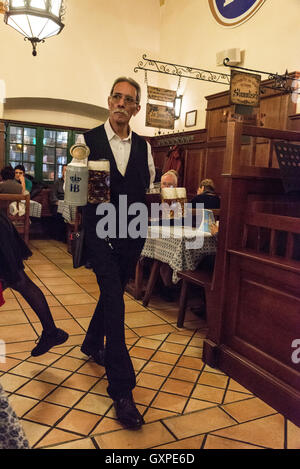 Un membro del personale di trasporto di massa di birra presso il famoso birrificio Hofbräuhaus a Am Platzl nel vecchio quartiere di Monaco di Baviera in Germania. Ho Foto Stock