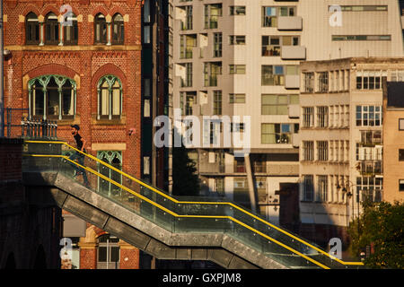 Manchester passaggi pedonali metro link Deansgate Locks utilizzando mobile walking golden sunshine fino andando scale esterno esterno s Foto Stock