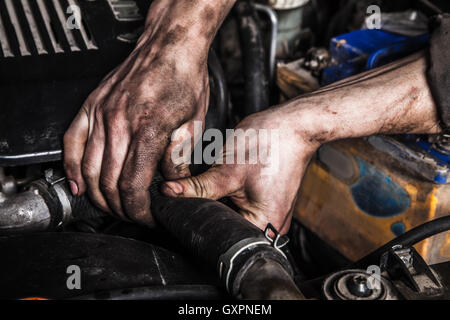 Lavorando gli uomini con le mani sporche e strumenti Foto Stock