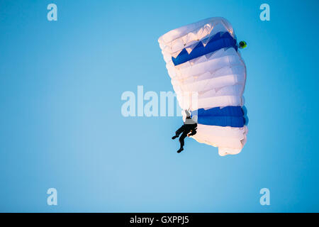 Paracadutista unico sul paracadute in blu cielo chiaro. Uno stile di vita attivo, Extreme hobby Foto Stock