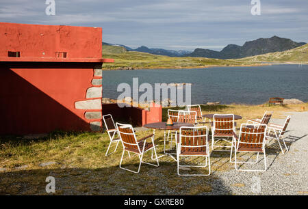 Svuotare i tavoli e le sedie pieghevoli al di fuori dell'albergo Bygdin sulle rive del lago Bygdin nel Parco nazionale di Jotunheimen Norvegia Foto Stock