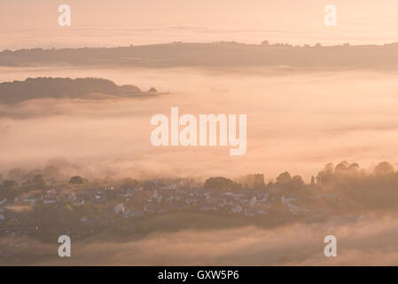 Chagford Chiesa e villaggio circondato da early morning mist, Parco Nazionale di Dartmoor, Devon, Inghilterra. In estate (Luglio) 2015. Foto Stock