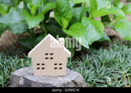 Giocattolo di legno casa in pietra, sfondo verde Foto Stock