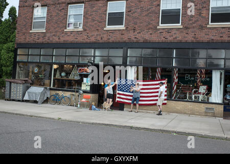 Amici mantenendo la bandiera americana in modo donna può prendere un selfie con stelle e strisce come sfondo. St Paul Minnesota MN USA Foto Stock