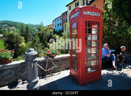 Due uomini su una panchina vicino al 'wee library' British casella Telefono a Barga in Toscana, Italia. La città ha una stretta affinità con la Scozia nel Regno Unito attraverso legami storici. Foto Stock