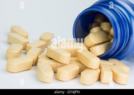 Raccolta compresse di colore giallo dalla caduta di una medicina blu jar Foto Stock