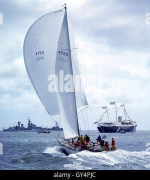 AJAX NEWS FOTO. 1971. SOLENT, Inghilterra. - ADMIRAL'S CUP - AMERICAN ENTRATA YANKEE GIRL poteri verso COWES strade con il Royal Yacht Britannia HMRY E GUARDSHIPS NAVALE IN BACKGROUND. Foto:JONATHAN EASTLAND/AJAX REF:C7105D6 2 Foto Stock