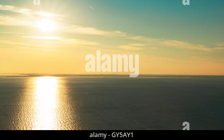 Fantastico tramonto con il sole si riflette nel mare calmo Foto Stock