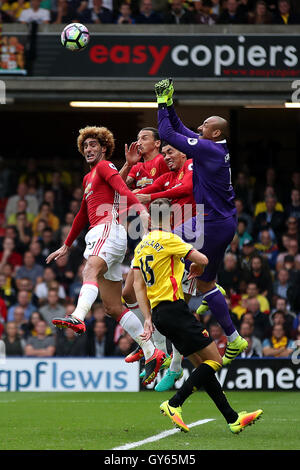 Watford portiere Heurelho Gomes (destra) punzoni la sfera chiara sotto pressione dal Manchester United giocatori durante il match di Premier League a Vicarage Road, Watford. Foto Stock