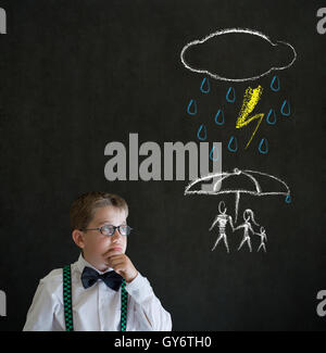 Pensando ragazzo uomo d affari pensando di proteggere la famiglia da disastro naturale su sfondo blackboard Foto Stock