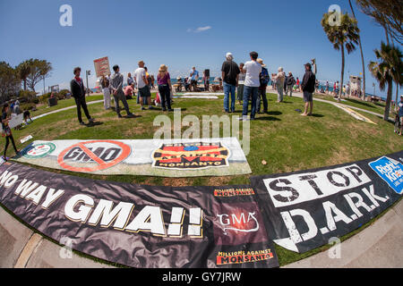 Un anziano gli indirizzi degli altoparlanti attivisti condannare geneticamente modificati prodotti agricoli (OGM) durante una dimostrazione presso la spiaggia principale in Laguna Beach, CA. Foto Stock