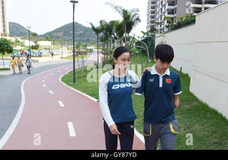 Rio De Janeiro, Brasile. Xiv Sep, 2016. Yang Hong (R) e Cai Liwen a piedi al Villaggio Paralimpico di Rio de Janeiro, Brasile, sul Sett. 14, 2016. Sedici-anno-vecchio Yang Hong e diciottenne Cai Liwen, membri di cinesi di nuoto paralimpico team, si aiutano reciprocamente per realizzare i loro sogni di campione durante il 2016 Rio Giochi Paralimpici. Yang Hong ha perso le sue braccia a dieci anni e Cai Liwen surffers cecità fin dalla sua infanzia. © Ou Dongqu/Xinhua/Alamy Live News Foto Stock