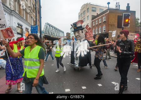 Londra, Regno Unito. 17 settembre 2016. Centinaia di soddisfare in Hoxton Square, molti indossando rosso, a marzo per sostenere il passaggio di nuvole, indipendente London music venue in Haggerston. Essi hanno marciato lungo il marciapiede al club un po' più di un miile lontano in un atmosfera di festa guidato da una grande figura di un avido capitalista con cinquanta pound note insaccata nella sua aveva e pende verso il basso la schiena e sono stati uniti in modo da parte di una band che suona su un autocarro. Passare nubi ospitato più di 10.000 eventi culturali e musicali sin dalla sua apertura nel 2006 si celebra il suo decimo anniversario quando ha appreso che il suo proprietario aveva segretamente Foto Stock