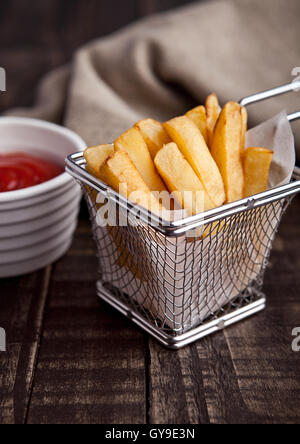 Frittura di patatine fritte chip nella friggitrice con ketchup su legno Foto Stock