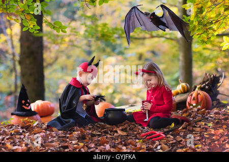 Due bambini divertenti indossando devil e vampire costume rosso con corna e trident trucco o trattamento di Halloween. Foto Stock