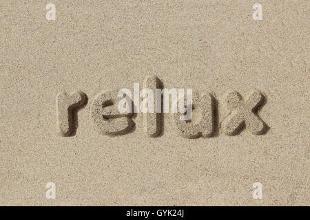 Rilassatevi scritto in lettere di sabbia. Molto semplice e grafica. Foto Stock