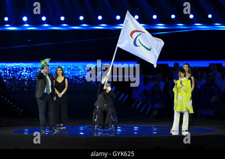 Il sindaco di Rio de Janeiro Eduardo Paes (sinistra) applaude come presidente della IPC Sir Philip Craven (centro) mani la Bandiera Paralimpica al Governatore di Tokyo Yuriko Koike durante la cerimonia di chiusura sull'undicesimo giorno del 2016 Rio Giochi Paralimpici al Maracana, Rio de Janeiro, Brasile. Foto Stock