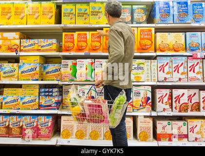 L'uomo l'acquisto di cereali per la prima colazione nel supermercato Tesco. Regno Unito Foto Stock