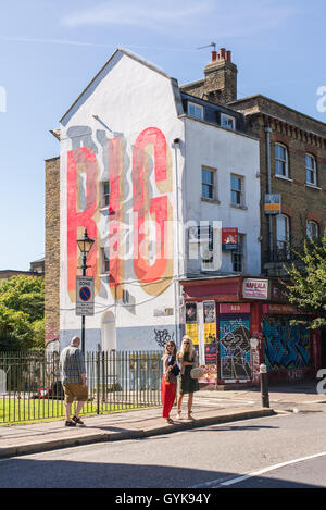 Persone che camminano su Hackney Road in Bethnal Green, East London, in una giornata di sole. Foto Stock