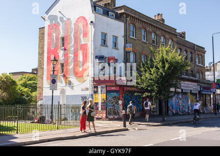 Persone che camminano su Hackney Road in Bethnal Green, East London, in una giornata di sole. Foto Stock