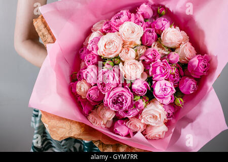 Luxury mazzi di fiori di colore rosa le peonie e le rose nelle mani delle donne. Foto Stock