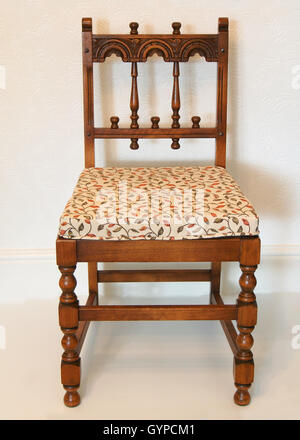 Metà secolo Ercol sedia scolpito nel "vecchio stile Coloniale di stile", realizzato in massello di rovere con un arazzo cuscino. Foto Stock
