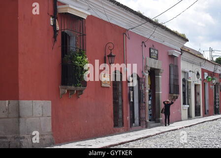 Persona che cammina su una strada tradizionale in Antigua, Guatemala Foto Stock