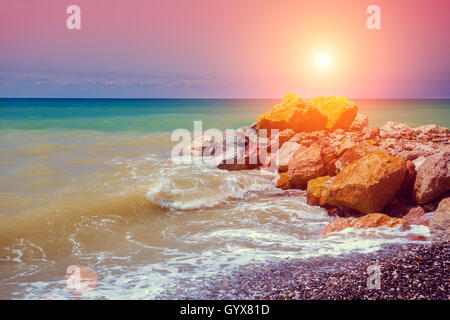 Tramonto sulla costa rocciosa Foto Stock