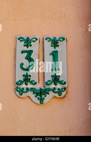 Dettaglio del numero civico in ceramica con antiche decorazioni in verde, trentuno. Foto Stock