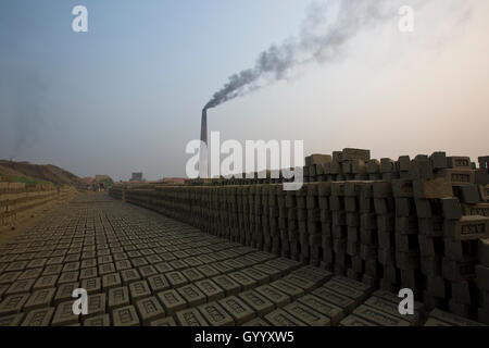 Un camino di una mattonaia emette fumo nero a Amin Bazar. Dacca in Bangladesh. Foto Stock