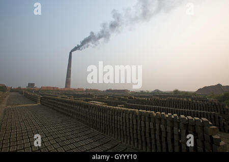 Un camino di una mattonaia emette fumo nero a Amin Bazar. Dacca in Bangladesh. Foto Stock